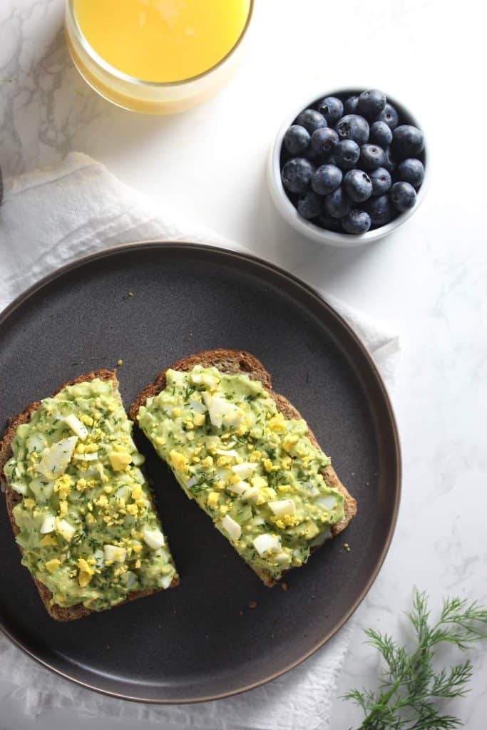 Avocado egg salad toast on grey plate.