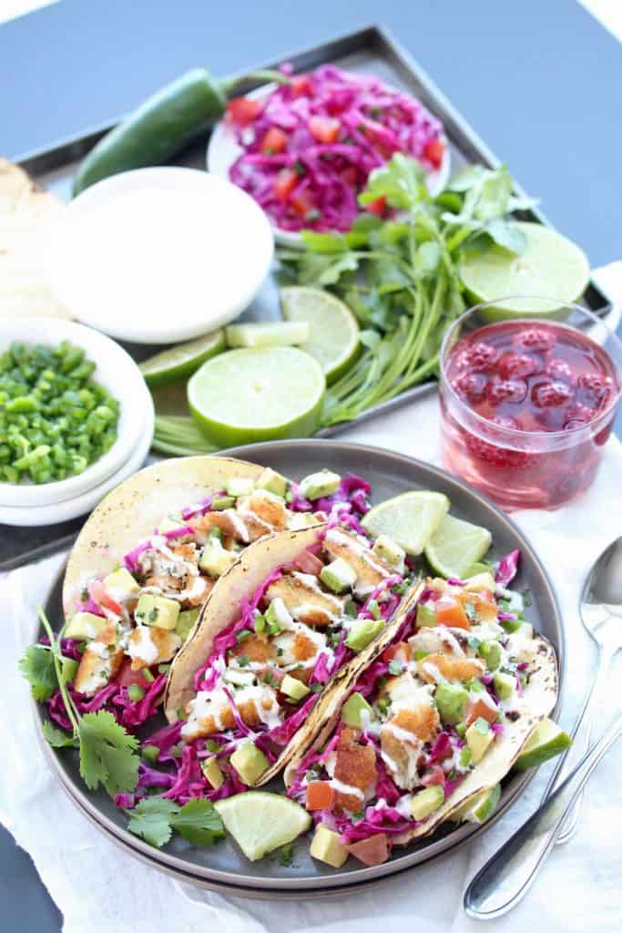 Three fish tacos on grey plate.