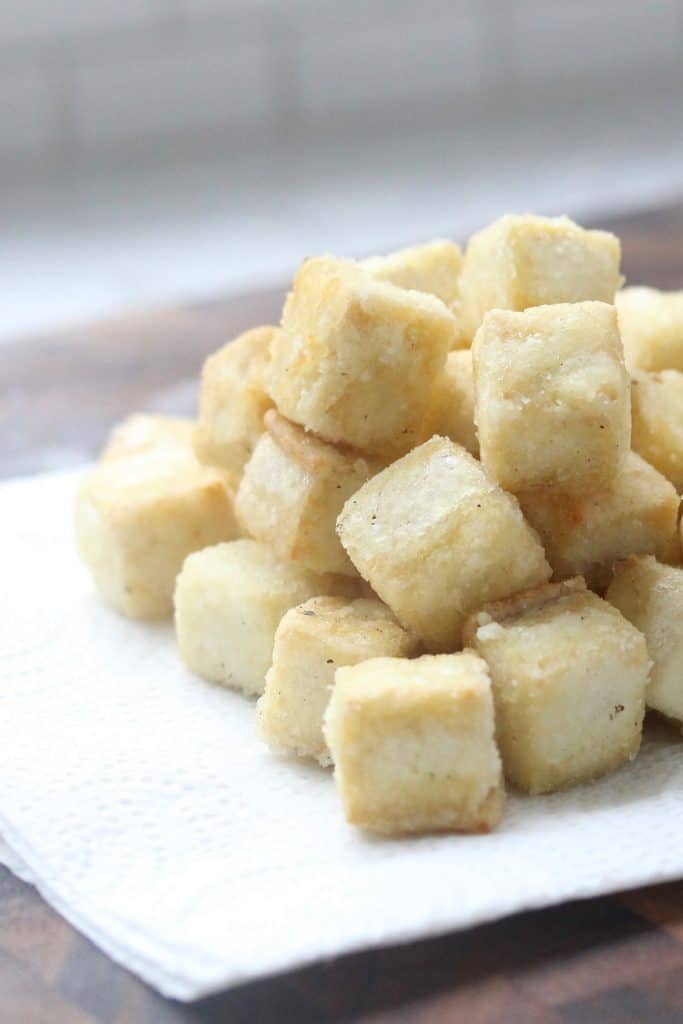 Crispy tofu cubes on paper towel.