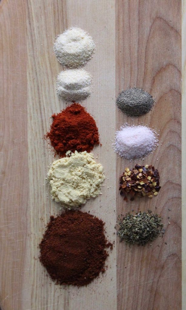 Spices on brown cutting board.