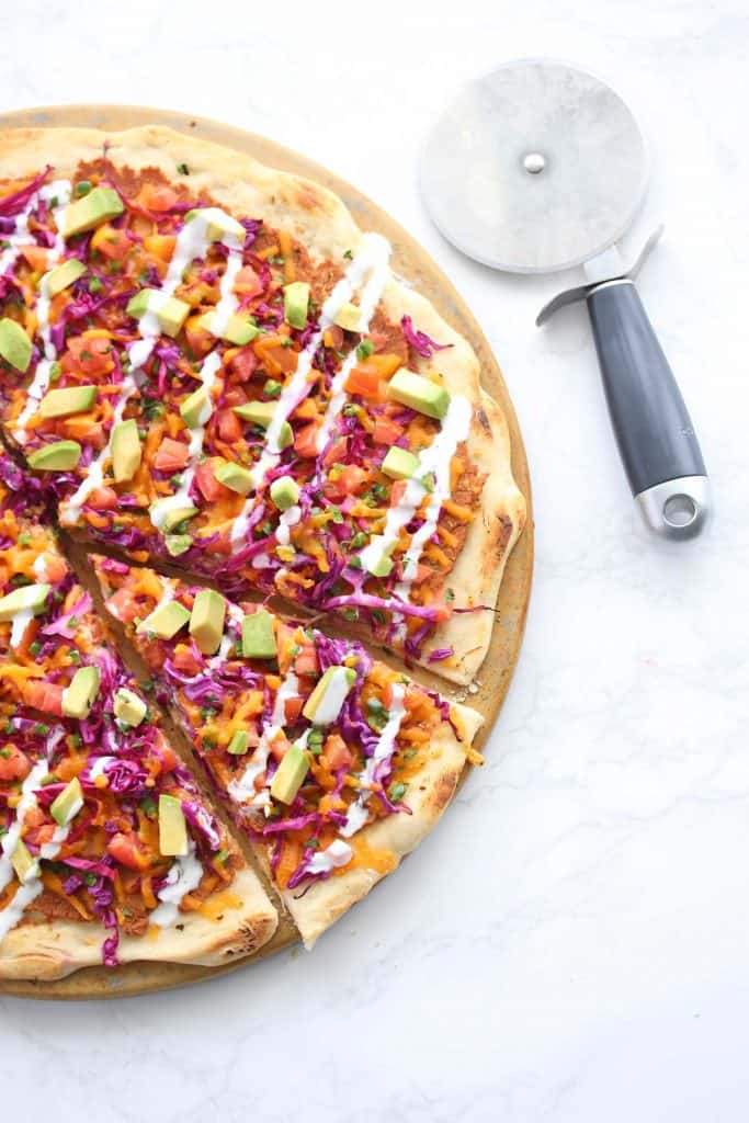 Colorful pizza on white surface.