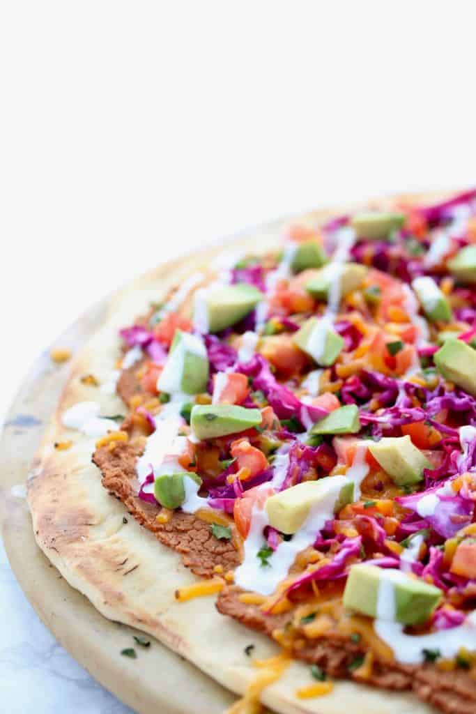 Colorful pizza on white surface.