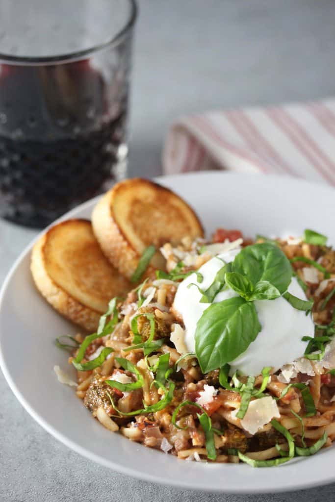 Spaghetti white toasted bread in a white bowl on grey surface.