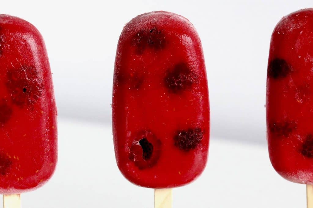 Red popsicle on white background.