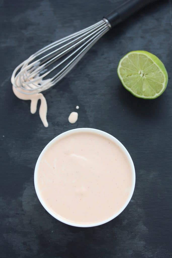 Aioli in white bowl on grey cutting board.